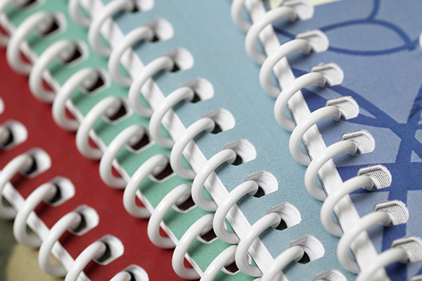 Close up view of multicolored reports with a white plastic coil binding